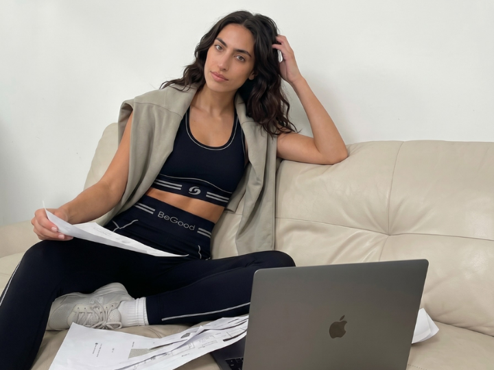 Woman sitting on a sofa wearing BeGood slimming shaping leggings, designed for comfort, support, and everyday wellness.