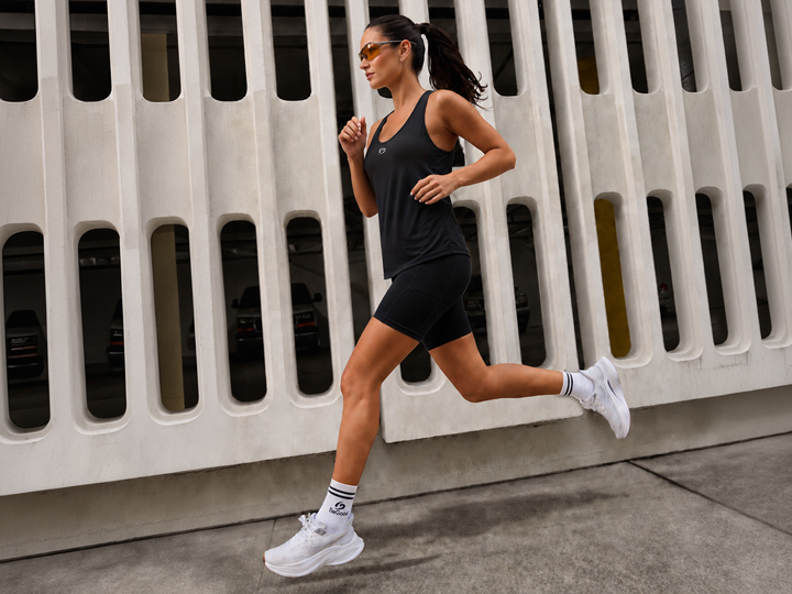 Donna che corre con leggings BeGood per stimolare la microcircolazione e il benessere delle gambe.